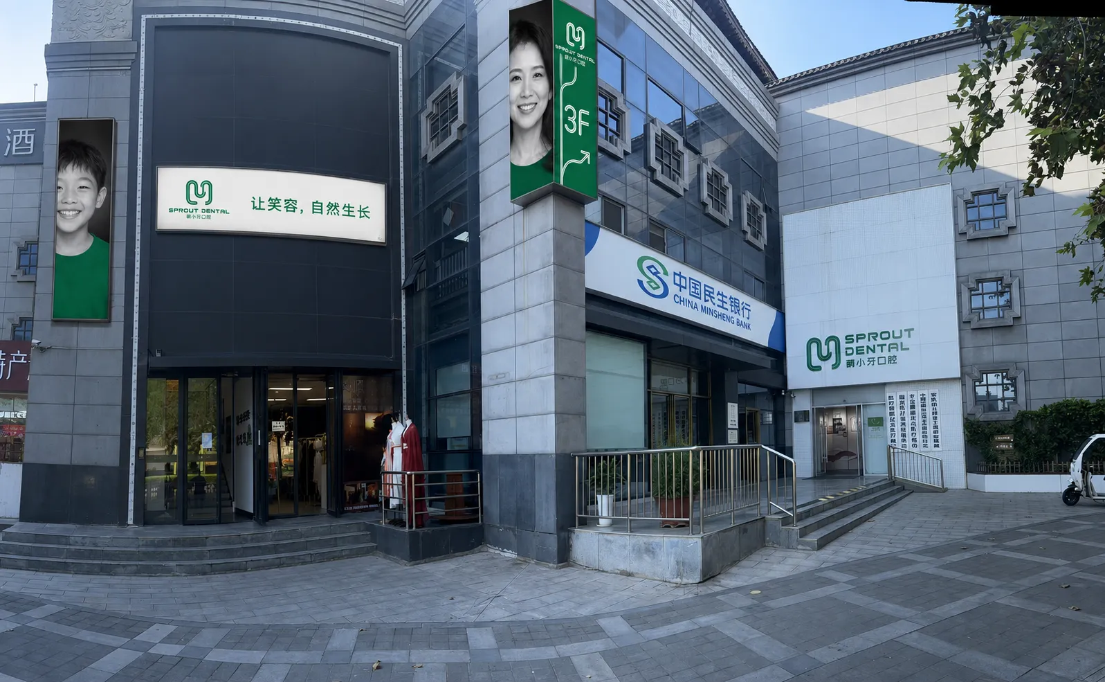 从街道方向看萌小牙口腔所在的东门里美博城，可见门诊绿色门头